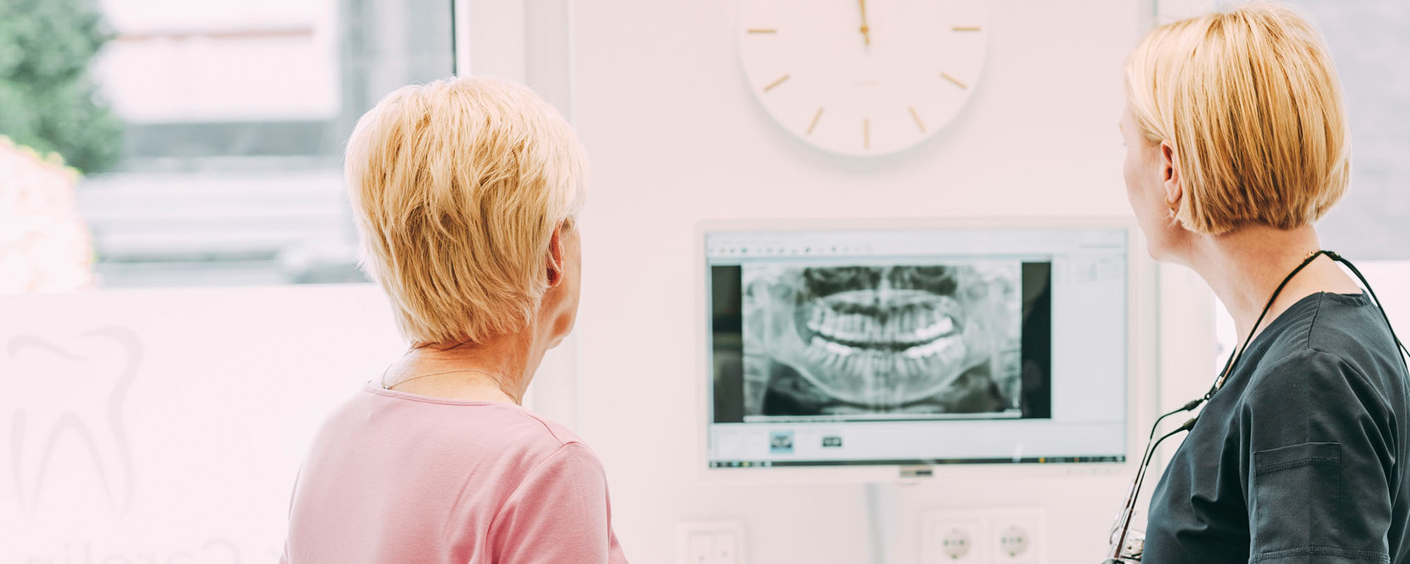 Frau Dr. Röder und eine Patientin stehen vor einem digitalen Röntgenbild in der Zahnarztpraxis Dr. Carolin Röder in Dinslaken