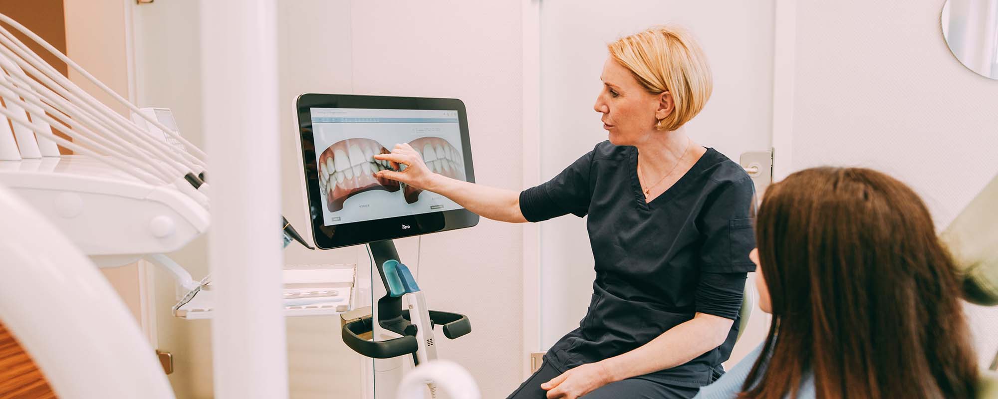 Frau Dr. Röder zeigt einer Patientin etwas an einem Bildschirm in der Zahnarztpraxis Dr. Carolin Röder in Dinslaken