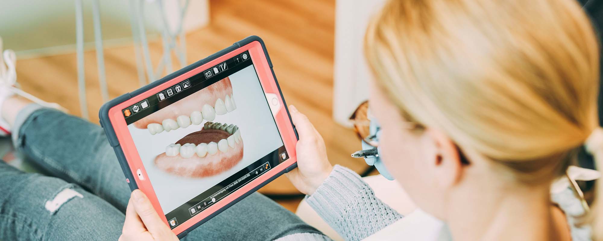 Eine Patientin schaut sich ein 3D Modell ihres Gebisses an in der Zahnarztpraxis Dr. Carolin Röder in Dinslaken