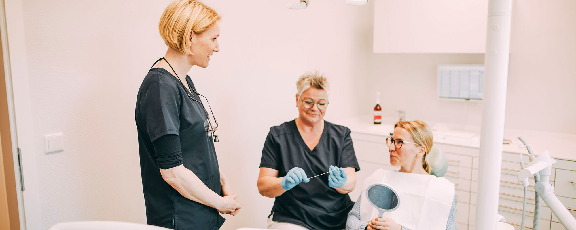 Zwei Mitarbeiterinnen in einem Patientengespräch in der Zahnarztpraxis Dr. Carolin Röder in Dinslaken